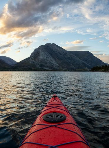 Kayaking in Glacier Lake surrounded by the Canadian Rocky Mountains Kayaking in Glacier Lake surrounded by the Canadian Rocky Mountains